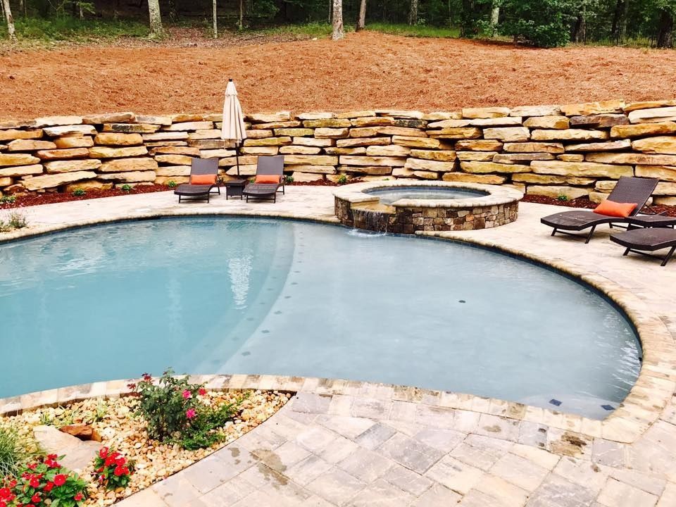 Free-form gunite pool with a stone wall in Hoover