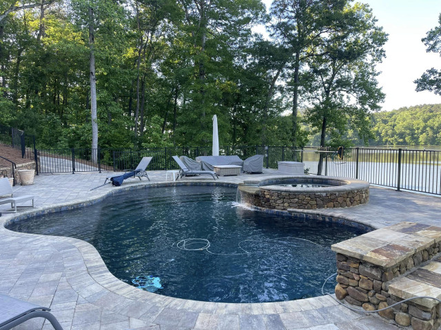 Luxury gunite pool on stylish patio with convenient outdoor shower and inviting fire pit